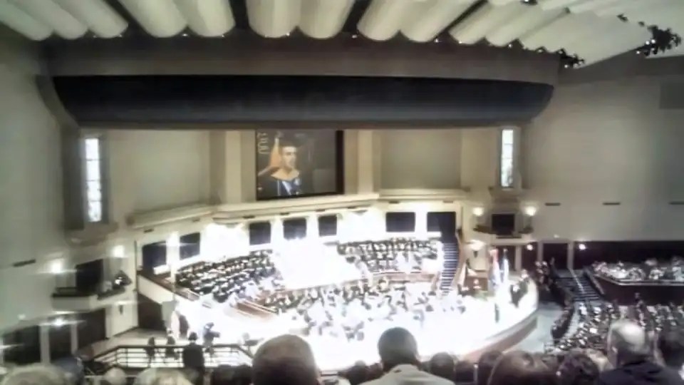 Wide view of the Pensacola Christian College auditorium at the 2012 nursing commencement, with Nathanael Elijah Smith shown on the large screen as he gives the nursing commencement speech.